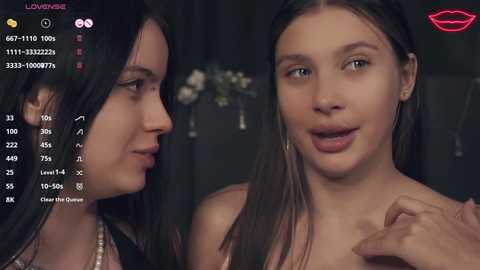 Media: Video of two young women, one with long dark hair, the other with straight brown hair, in a dimly lit room, engaged in conversation.