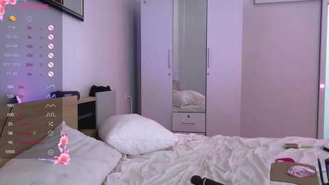 Media: Video of a messy, pastel-colored bedroom with a bed, white sheets, and a mirror wardrobe, showcasing a cluttered nightstand with cosmetics.