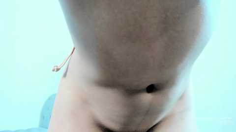 Media: Video of a close-up, blurry view of a naked person with fair skin, showing a receding hairline and a small belly button. The background is a light blue.