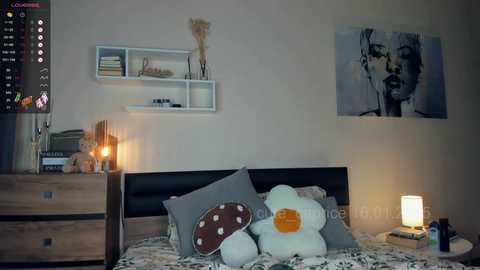 Media: Video of a cozy bedroom with a black bed, white shelves, a stuffed duck, and a lit lamp. A large Marilyn Monroe poster and a wooden dresser with a candle are visible.