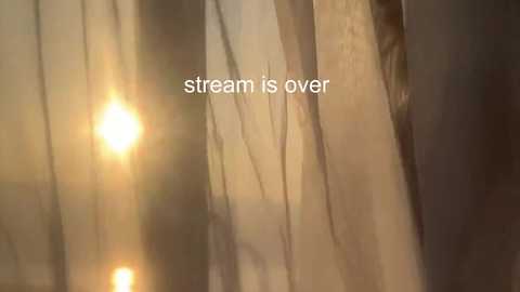 Media: A video of a stream of sunlight filtering through sheer, light-colored curtains, creating a warm, golden glow. The text \"stream is over\" is superimposed in the center of the image.