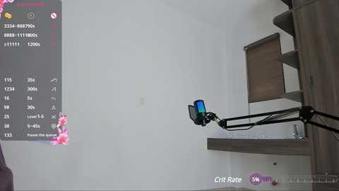 Media: Video of a grey wall with a black microphone attached to a wooden shelf, displaying a pink flower graphic and a \"Crit Rate\" notification on a smartphone screen.