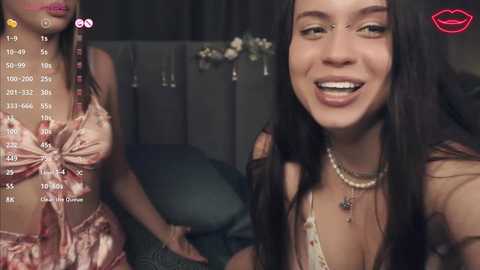 Media: Video of two young women, one with long dark hair and a floral dress, the other smiling with long dark hair, both indoors with blurred background.