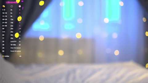 Media: A video depicting a blurry bedroom with bokeh lights, a bed, and a partially visible person. The background features a blue hue, likely from a screen. The left side includes a digital display with icons and text.