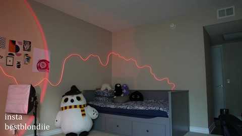 Media: A video of a dorm room with a white stuffed penguin, a bed with a blue comforter, a black hat, and red LED lights outlining the room's perimeter.