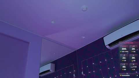 Media: A video of a modern, dimly lit interior with a purple hue, featuring a white ceiling with recessed lights, two air conditioning units, and a digital display showing temperature and humidity levels.