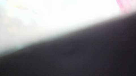 Media: A blurry, out-of-focus video of a light-colored object, possibly a person, standing in front of a dark background. The image lacks sharp details, making it difficult to discern specific features or colors.