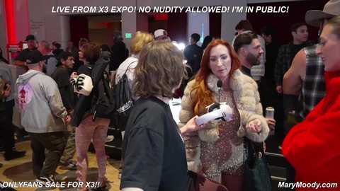 Media: Video of a crowded nightclub scene with a red-haired woman in a fur coat and a man in a black jacket. Text overlays read, \"Live From X Expo! No nudity allowed! I'm in public!\