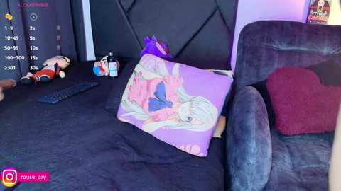 Media: A video of a cozy bedroom with a plush, dark purple couch, a purple pillow with a cartoon girl, plush toys, a keyboard, and a poster.