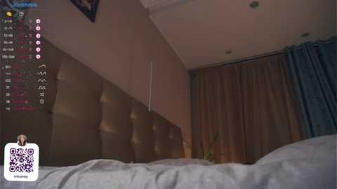 Media: Video of a dimly lit bedroom with a large bed, textured brown headboard, beige walls, and dark curtains. A QR code and a Twitch stream overlay are visible.