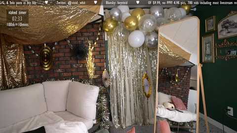 Media: Video of a cozy living room with a white sofa, golden tinsel, silver balloons, brick wall, and a green accent wall.