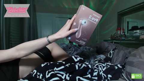 Media: A video of a person lying on a bed, holding a \"Sonicare\" toothbrush box, with a blurred reflection and green light effects in the background.