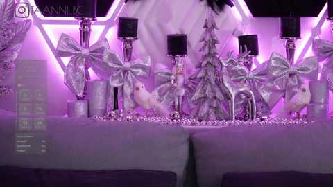 Media: Video of a luxurious, purple-themed Christmas display with sparkling silver bows, white feathers, and a lit tree, featuring a large, ornate centerpiece and delicate ornaments.