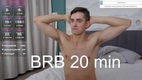 Media: Video of a shirtless young man with short brown hair, flexing his muscles in a bedroom with gray bedding, blue wall, and BBR 20 min timer overlay.