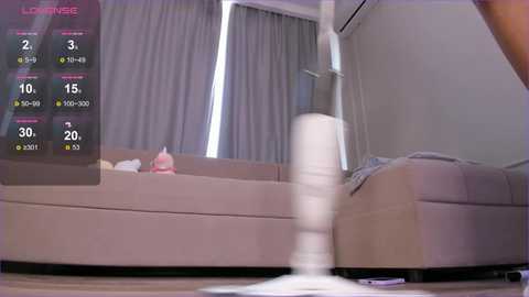 Media: A video of a modern living room with a large beige sectional sofa, a white floor lamp, and light-colored curtains. A digital overlay shows a fitness game progress, indicating 30% completion.