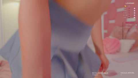 Media: A blurry video of a woman in a blue dress, taken from a low angle, showing her cleavage and part of her face. The background features a pink bed and a red headboard.