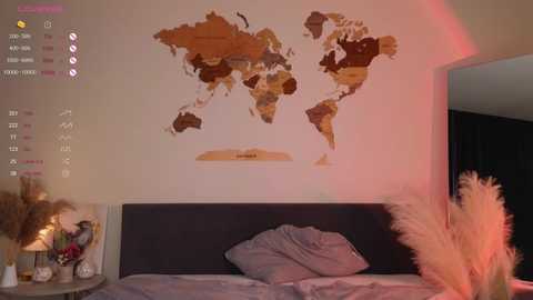 Media: Video of a modern bedroom with a wooden world map wall decal, a dark wooden headboard, beige bedding, and pampas grass decor.