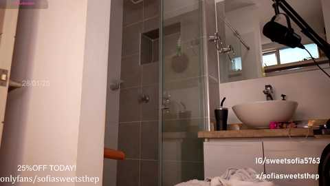 Media: Video of a modern, minimalist bathroom featuring a white sink, glass shower, beige tiles, and a black microphone on the counter, with captions promoting OnlyFans content.