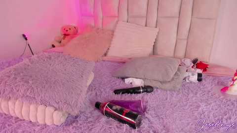 Media: A video of a pink-lit bedroom with plush toys, a fluffy purple rug, and scattered sex toys, including a black vibrator.