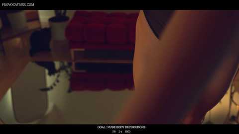 Media: A close-up CGI screenshot from the film \"Prom Night,\" showing a red couch, a wooden table, and a white chair in a dimly lit room.