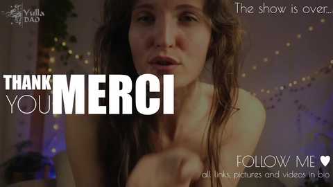 Media: Video of a fair-skinned woman with wet, wavy brown hair, holding a phone, showing gratitude with \"THANK YOU MERCI\" text. Background features dim lights, blurred, with text \"The show is over,\" \"Follow Me,\" and \"all things pictures and videos on blog.\