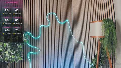 Media: Video of a modern room with a vertical, striped wood wall, a green neon light curving on it, a potted plant, and a floor lamp.