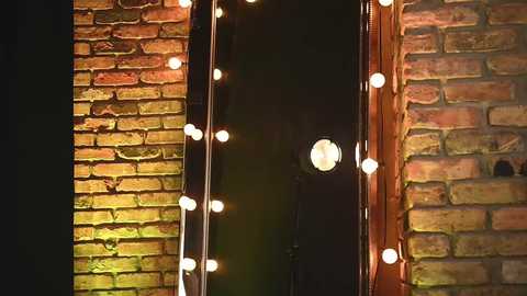 Media: Video of a brick wall with a narrow gap, adorned with a string of warm white fairy lights, casting a cozy glow. The brick texture contrasts with the soft, round bulbs, creating a charming, rustic ambiance.