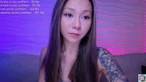 Media: A video of an East Asian woman with long straight hair, tattoos, wearing a tank top, set against a purple and pink wavy background. Text overlay: \"Hickey pussy pattern- 50k, shoke pattern- 95k, well pussy pattern- 115k, 50k.\