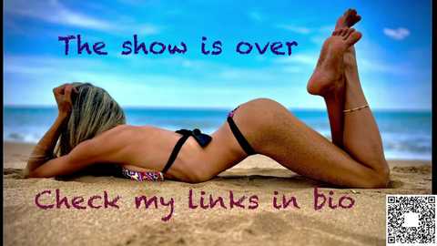 Media: Video of a blonde woman in a black bikini lying on a sandy beach, with the ocean and sky in the background. Text reads, \"The show is over. Check my links in bio.\