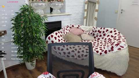 Media: Video of a cozy living room with a leopard-print couch, white fluffy rug, green plant, and a black chair in the foreground, showing a calendar overlay.