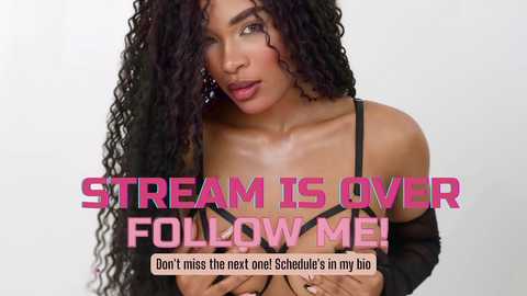 Media: Video of a Black woman with long, curly black hair, wearing a black bra and sheer top, looking sultry. Text overlays read: \"STREAM IS OVER FOLLOW ME!\" and \"Don't miss the next one! Schedule's in my bio.\