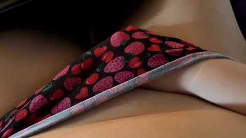 Media: A video of a woman's smooth, tan skin with a black, pink, and green patterned bikini bottom pulled down, revealing her bare, curvy buttocks. The background is blurred.