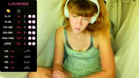 Media: A video shows a young girl with curly blonde hair wearing headphones, a green tank top, and gray pajama pants, sitting on a white bed with a digital screen displaying various audio settings.