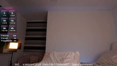 Media: A video of a dimly lit bedroom with a bed, a striped wall, a lamp, and a partially visible calendar displaying various dates.