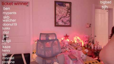 Media: Video of a pink-themed room with a large teddy bear, toys, and a plush rug, lit by pink lights, with a white door and framed artwork. Text overlays list various search terms.