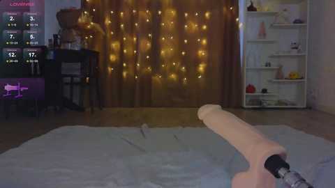 Media: A video of a cozy bedroom with a wooden floor, a large window draped in fairy lights, a white bookshelf, and a person using a VR headset with a large, realistic-looking penis.