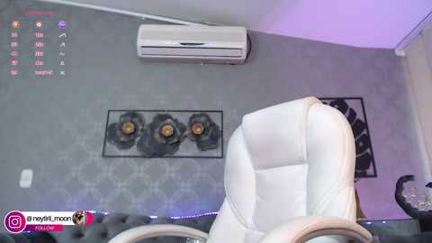 Media: Video of a modern office with a white leather chair, gray wall, three black speakers, and an air conditioner.