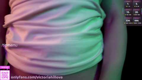Media: Video of a woman's midsection in a white, crumpled shirt with a hint of green and purple light. Text overlay includes a watermark and a QR code.