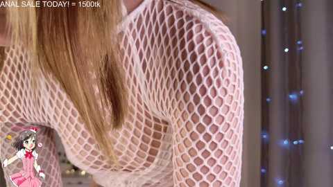 Media: A video of a woman with long, straight, light brown hair, wearing a white fishnet top revealing her large breasts. Background includes fairy lights and a pink toy.
