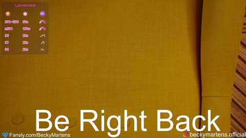 Media: Video of a yellow wall with a digital clock displaying time and date in the top left corner. Text at the bottom reads \"Be Right Back\" in bold white letters.