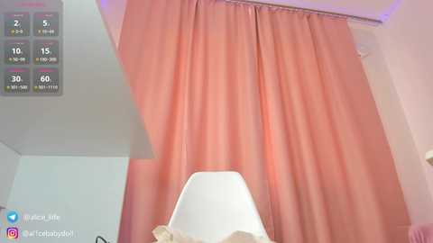 Media: A video of a minimalist room with peach-colored curtains and a white chair, overlaid with a digital weather forecast. The room has a modern, clean aesthetic.