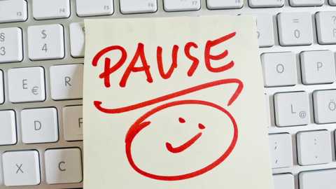 Media: Video of a handwritten sticky note with \"PAUSE\" and a smiling face drawn in red marker placed on a white computer keyboard.