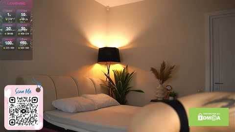 A video of a modern, dimly lit bedroom with a white bed, black lamp, potted plant, and a digital weather display.