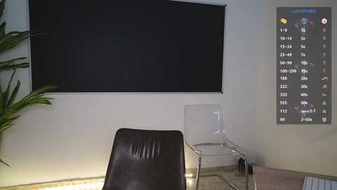 Media: Video of a minimalist room with a black screen, clear chair, and a large digital clock on the wall, featuring a digital clock with various time zones and settings.