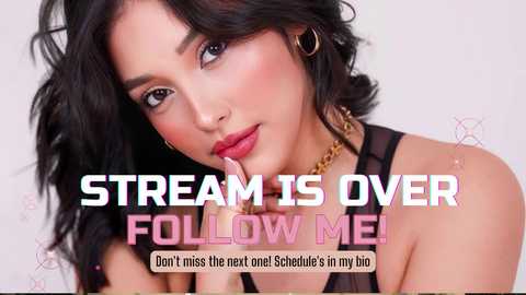 Media: Video of a young woman with long, wavy black hair, wearing gold hoop earrings and a black top. She has a light tan complexion and a soft smile. Text overlay reads, \"STREAM IS OVER FOLLOW ME!\