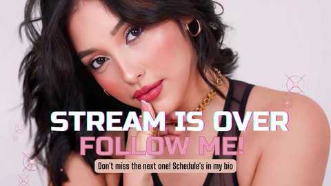 Media: Video of a beautiful young woman with wavy black hair, fair skin, and full lips, wearing a black tank top. Text reads: \"STREAM IS OVER FOLLOW ME!\" in bold, colorful fonts.