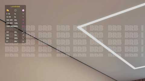 Video of a modern, minimalist room with beige walls and a large, white geometric ceiling light. On the left, a digital clock display shows the time, with a clear, crisp font and black and white color scheme.
