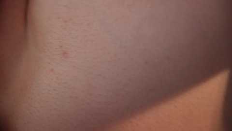 Media: A close-up video of a person's lower back showing a cluster of small, red spots and slight skin texture variations. The background is blurred, focusing solely on the skin.