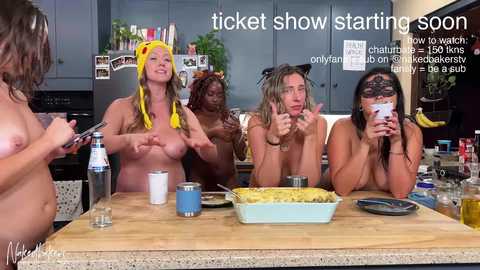 Video of three nude women in a kitchen, one holding a phone, one with a yellow hat, and one with a mask. Caption: \"Ticket show starting soon.\