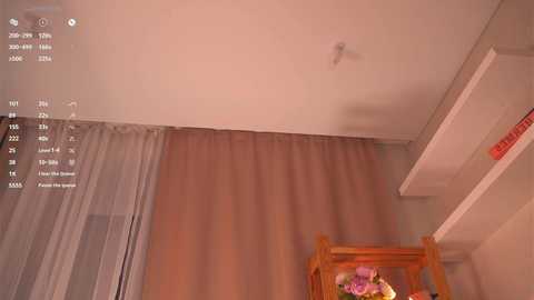 Video of a cozy bedroom with beige curtains, a wooden chair, and a bookshelf. A digital clock display shows the time as 12:30 AM.